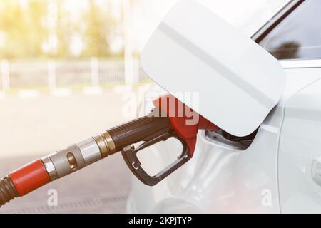 Concept transport et industrie. Remplissage de la voiture. Une vanne de ravitaillement est insérée dans le goulot de remplissage de carburant. Banque D'Images