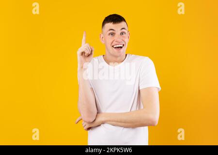 Eureka. Jeune homme caucasien excité ayant une excellente idée, trouver l'inspiration ou la solution au problème, fond jaune Banque D'Images