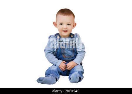 Bébé garçon heureux assis dans une tente pour enfants, salle de jeux, isolé sur un fond blanc. Enfant d'un an Banque D'Images