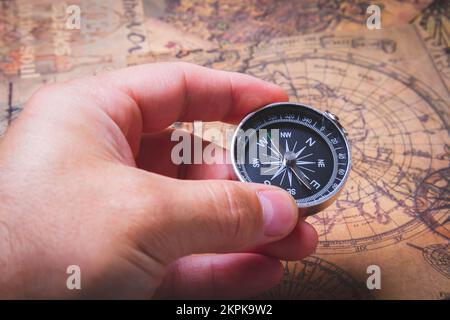 Recherche d'aventure. Boussole et cartes. Chasse au Trésor sur l'île. Carte des pirates. Personne tient le compas dans sa main. Banque D'Images