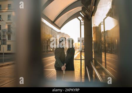 Couple heureux tenant les mains debout à un arrêt de tramway le matin, Biélorussie Banque D'Images