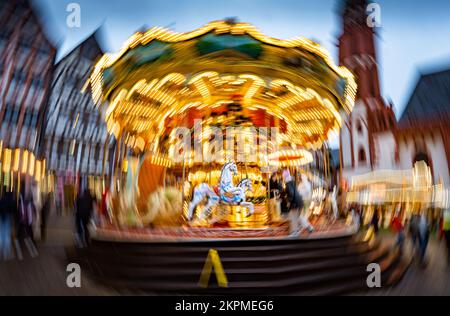 28 novembre 2022, Hessen, Francfort-sur-le-main : des figures de chevaux tournant avec le carrousel pour enfants nostalgique au marché de Noël de Francfort (tourné avec un appareil photo à mouvement circulaire et un temps d'exposition plus long). Photo: Frank Rumpenhorst/dpa Banque D'Images