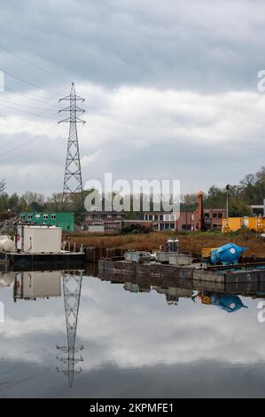 Erembodegem, région flamande de l'est, Belgique, 11 04 2022 - grues industrielles et conteneurs de cargaison d'un port se reflétant dans la rivière Dender Banque D'Images