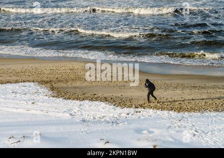 Kaliningrad, Mer Baltique, Russie, 31 janvier 2021. Un homme marche le long de la mer. Neige et vent sur la rive de la mer. Banque D'Images