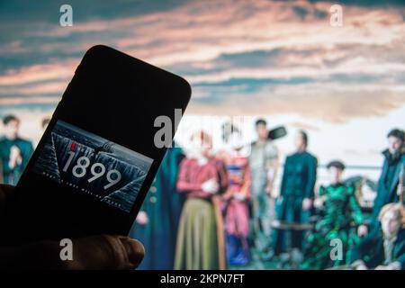 Rheinbach, Allemagne 28 novembre 2022, le logo de la nouvelle série Netflix '1899' sur l'écran d'un smartphone devant le téléviseur Banque D'Images