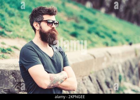 Concept de barbershop et de style. Homme avec la barbe et la moustache sur le visage strict, le fond de la nature, défoqué. La taille basse avec barbe est assurée Banque D'Images