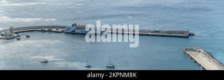 Porto Santo, 2022 octobre 13, paysage avec ferry-boat amarré dans le port étincelant des eaux de l'océan Atlantique à Vila Baleira, tourné dans la lumière d'automne Banque D'Images