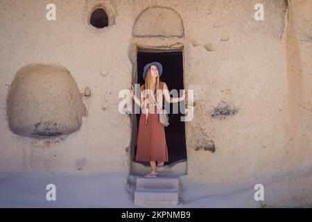 Jeune femme explorant la vallée avec des formations rocheuses et des grottes de fées près de Goreme en Cappadoce Turquie Banque D'Images