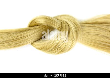 Boucle de cheveux blonds nouée. Verrou de cheveux ondulés blonds sur fond blanc, vue du dessus Banque D'Images