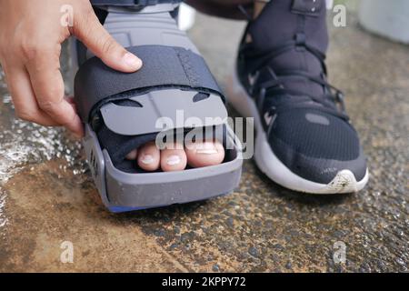 femmes pieds cassés avec une chaussure en plastique gris cheville corset blessure protégeant la chaussure Banque D'Images