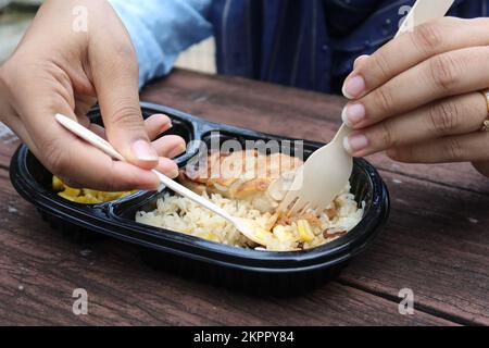 curry de poulet et de riz dans un sachet en plastique à emporter sur la table Banque D'Images