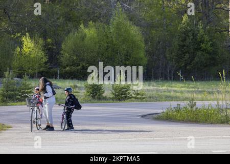 Belle vue de la mère et de ses deux enfants sur les vélos dans la zone verte. Concept de mode de vie actif. Suède. Uppsala. Banque D'Images