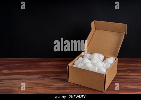 Ouvrir la boîte en carton remplie de mousse d'emballage sur une table Banque D'Images