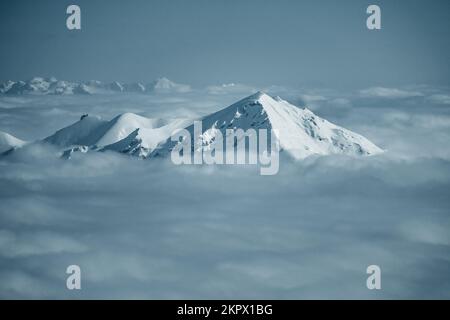 Sommets enneigés des montagnes à travers les nuages dans les Alpes autrichiennes, Gastein, Salzbourg, Autriche Banque D'Images