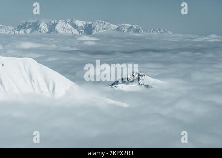 Sommets enneigés des montagnes à travers les nuages dans les Alpes autrichiennes, Gastein, Salzbourg, Autriche Banque D'Images