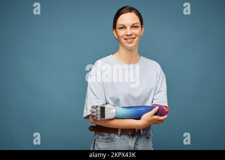 Studio portrait de jeune femme positive avec bras bionique Banque D'Images