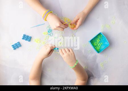 Concept de fabrication de bracelets de métier par les enfants bleu et jaune Banque D'Images