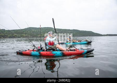 Deux hommes pêchent à l'achigan à partir de kayaks sur Possum Kingdom Lake Texas Banque D'Images