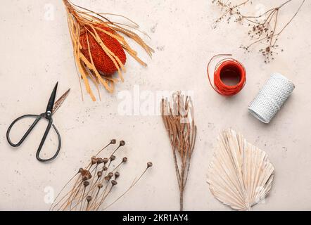 Fleurs séchées avec feuilles, fils et ciseaux sur fond blanc Banque D'Images