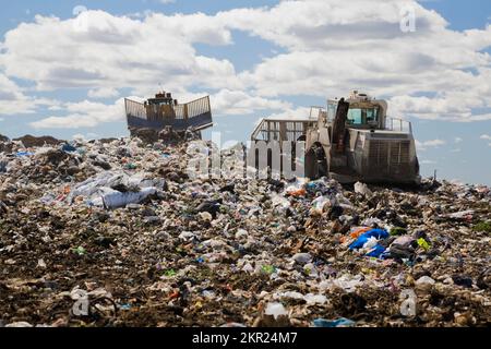 Compacteurs d'enfouissement qui dispersent et compactent les débris et les déchets rejetés sur le site de gestion des déchets de Terrebonne (Québec), Canada. Banque D'Images