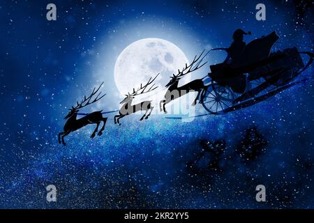 Père Noël avec renne volant sur fond de pleine lune Banque D'Images