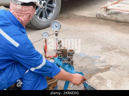 Le technicien utilise le compresseur d'azote pour contrôler le fonctionnement de la soupape de sécurité en vue d'un essai annuel en usine. Banque D'Images