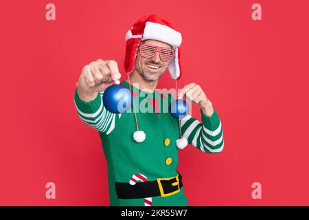 Joyeux Noël. homme heureux en costume d'orf et chapeau du père noël. guy dans des lunettes de fête Banque D'Images