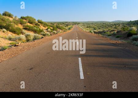 Matin dans le désert avec une route vide ou une route nationale en haut passant par le désert. Horizon lointain, été chaud au désert de Thar, Rajasthan, Inde. Banque D'Images