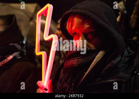 Un manifestant tient un éclair rouge - le symbole de la grève des femmes pendant la manifestation devant la maison de Kaczynski à Varsovie. À l'occasion de l'anniversaire de 104th du droit de vote des femmes en Pologne, Des centaines de Polonais ont protesté à Varsovie contre ce qu'ils ressentent comme un mépris envers les femmes et une érosion de leurs droits sous le parti conservateur droit et Justice (PiS), devant la maison du chef du parti Jaroslaw Kaczynski. Les manifestants s'opposent à une interdiction quasi totale de l'avortement imposée par le parti il y a deux ans. Ils sont en colère contre Kaczynski lors d'une réunion publique récemment blâmée Banque D'Images