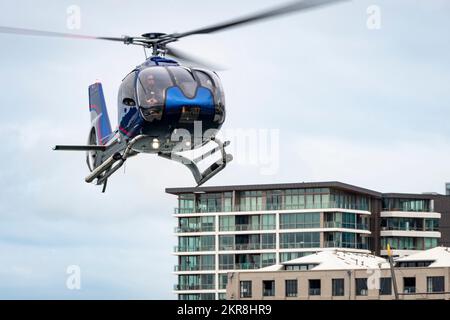 Hélicoptère survolant à basse altitude près des bâtiments de la ville, Wellington, Île du Nord, Nouvelle-Zélande Banque D'Images