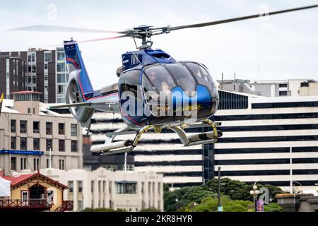 Hélicoptère survolant à basse altitude près des bâtiments de la ville, Wellington, Île du Nord, Nouvelle-Zélande Banque D'Images