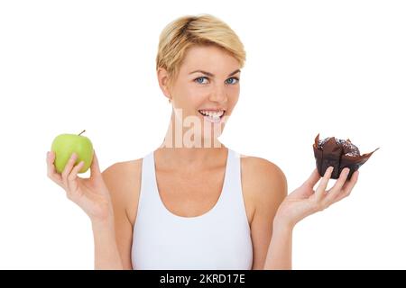 Que choisiriez-vous IVE a fait mon choix. Une jeune femme tenant une pomme dans une main et un doux plaisir dans l'autre - image isolée. Banque D'Images