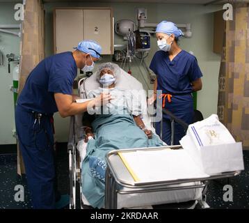 CARTAGENA (Colombie) (14 novembre 2022) le lieutenant Jesus Grandez, affecté au navire de l'hôpital USNS Comfort (T-AH 20), est parti, et un traducteur bénévole, parle avec un patient en attente de chirurgie du nez dans une salle d'opération à bord du Comfort à Cartagena (Colombie), le 14 novembre 2022. Comfort est déployé à la flotte américaine 4th afin de soutenir la poursuite de Promise 2022, une mission d'aide humanitaire et de bonne volonté qui mène des soins médicaux directs, des soins vétérinaires expéditionnaires et des échanges d'experts en la matière avec cinq pays partenaires des Caraïbes, d'Amérique centrale et d'Amérique du Sud. Banque D'Images