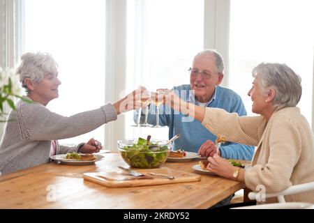 À de bons amis et de la bonne nourriture. Un homme âgé et deux femmes âgées qui déjeunent. Banque D'Images