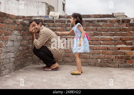 Père jouant cacher et chercher avec sa fille dans l'arrière-cour Banque D'Images