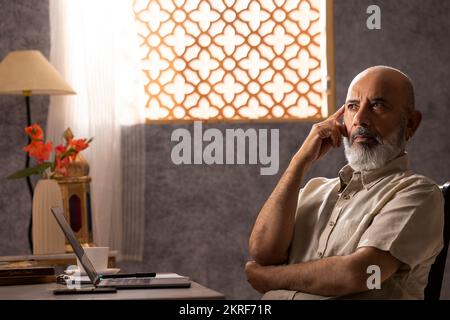 Portrait d'un homme senior réfléchi avec la main sur la tête Banque D'Images