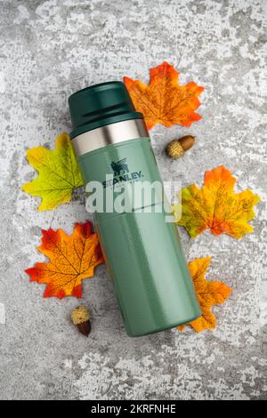 Antalya, Turquie - 28 novembre 2022: Stanley action Trigger thermos mug avec des feuilles dans les couleurs d'automne sur fond de pierre Banque D'Images