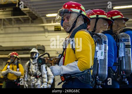 SAN DIEGO (16 novembre 2022) les marins affectés au département de l’air de l’USS Boxer (LHD 4) simulent la lutte contre un incendie de station-service au cours d’un exercice d’entraînement dans la baie hangar. Boxer est un navire d'assaut amphibie de classe Wasp, qui a été porté à San Diego. Banque D'Images