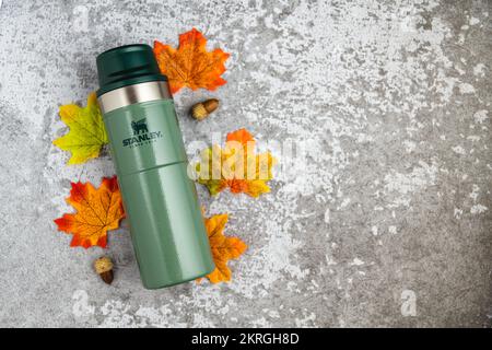 Antalya, Turquie - 28 novembre 2022: Stanley action Trigger thermos mug avec des feuilles dans les couleurs d'automne sur fond de pierre Banque D'Images