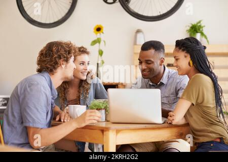 Ils se sont traîner dans leur café préféré. Un groupe d'amis qui traînaient dans un café avec un ordinateur portable. Banque D'Images