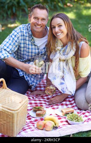 Profitez d'une journée romantique à l'extérieur. Portrait d'un couple marié profitant d'un pique-nique à l'extérieur. Banque D'Images