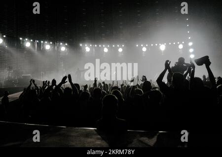 SILHOUETTE DE LA FOULE, ATMOSPHÈRE, U2 VERTIGO WORLD TOUR, 2005 : la foule de 64 000 personnes se déchaîne pour U2 alors que les lumières s’éteignent au début du concert du Millennium Stadium à Cardiff, juin 29 2005. Photo : ROB WATKINS INFO : The U2 Vertigo Tour, qui s'étend sur 2005-2006, a fait la promotion de leur album "How to Dismantle an Atomic Bomb". Connue pour ses performances énergiques et sa conception élaborée de la scène, la tournée a été un succès mondial, mettant en vedette des tubes comme 'Vertigo' et renforçant le statut de U2 en tant que légende du rock. Banque D'Images