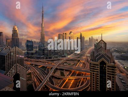 Vue aérienne du centre-ville avec gratte-ciels contemporains près de l'autoroute de Dubaï au coucher du soleil dans un ciel coloré Banque D'Images