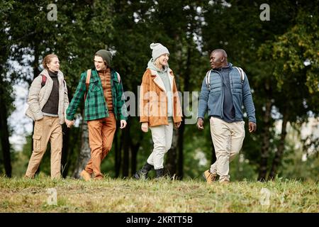 Portrait complet d'un groupe souriant d'amis qui s'amusent à marcher dans la forêt d'automne Banque D'Images