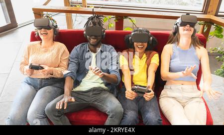 Une équipe de jeunes joueurs qui patent des jeux vidéo portant de nouveaux micro-casques pour la réalité virtuelle, les nouvelles technologies et le divertissement pour les jeunes influenceurs Banque D'Images