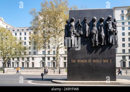 Londres, Royaume-Uni - 16 avril 2022 : les gens marchent à côté du monument de bronze aux femmes de la Seconde Guerre mondiale sur Whitehall à Westminster. Printemps à Londres. Banque D'Images