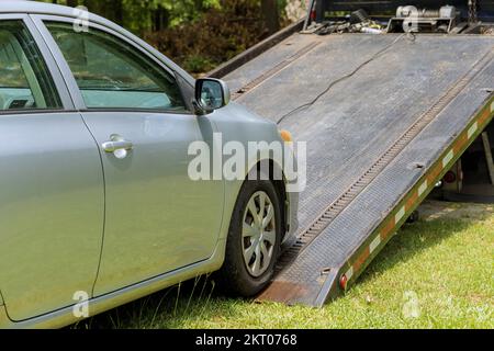 Chargement d'une voiture brisée endommagée sur un véhicule de remorquage en service de remorquage Banque D'Images