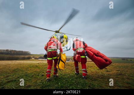 Deux ambulanciers paramédicaux avec harnais de sécurité et équipement d'escalade allant au service médical d'urgence de l'hélicoptère. Thèmes sauvetage, aide et espoir. . Banque D'Images