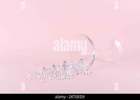 Aménagement créatif en verre martini avec diamants sur fond rose pastel. Concept de fête minimal. Banque D'Images