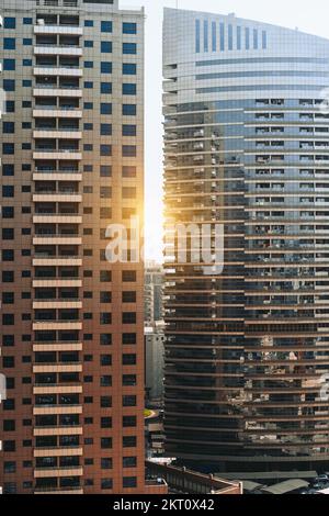 Vue verticale de deux gratte-ciel résidentiels modernes avec des motifs de façades de verre sur un coucher de soleil avec une lumière ; vue de deux habitation contemporaine haut- Banque D'Images